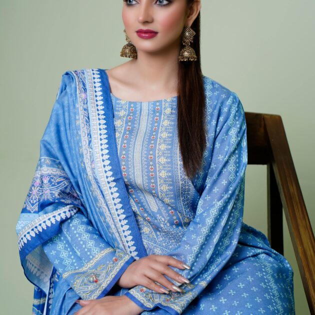 A model in blue traditional Indian attire poses elegantly indoors, highlighting fashion and cultural beauty.